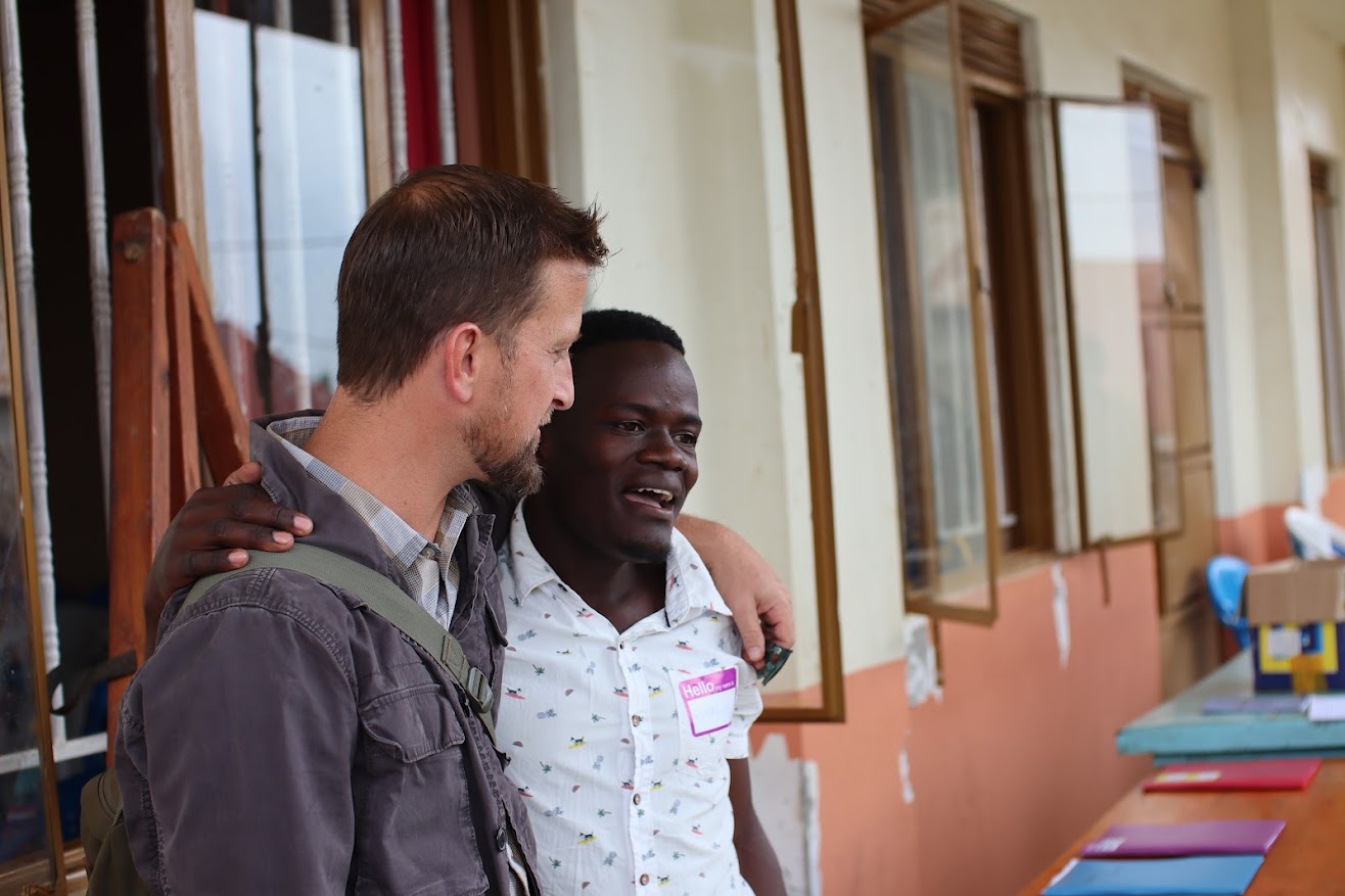 Adult man with his arm around an adolescent boy who is wearing a name tag