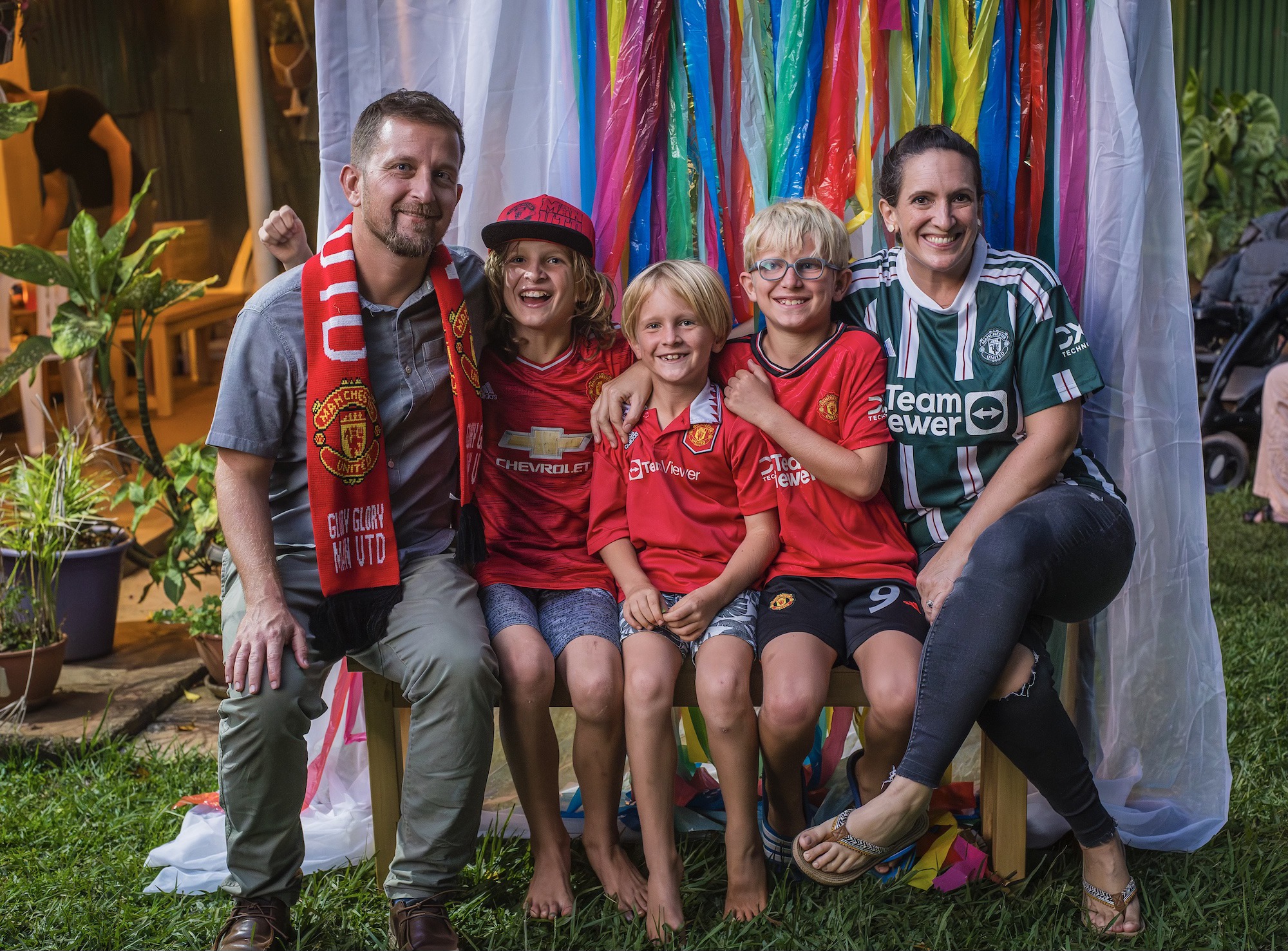 Mother and father on bench with three young boys in the middle