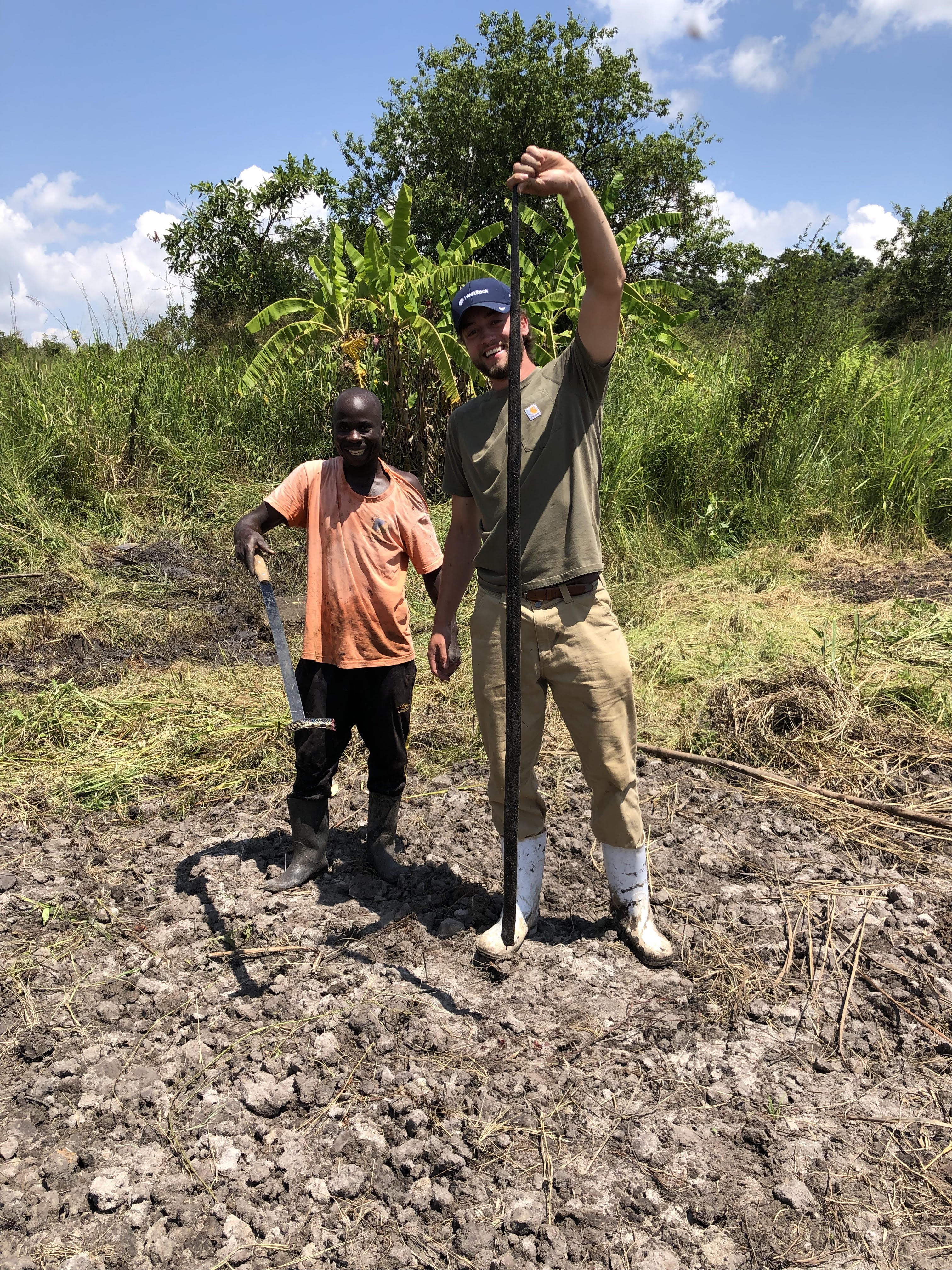 Dead forest cobra Two men holding a dead snake