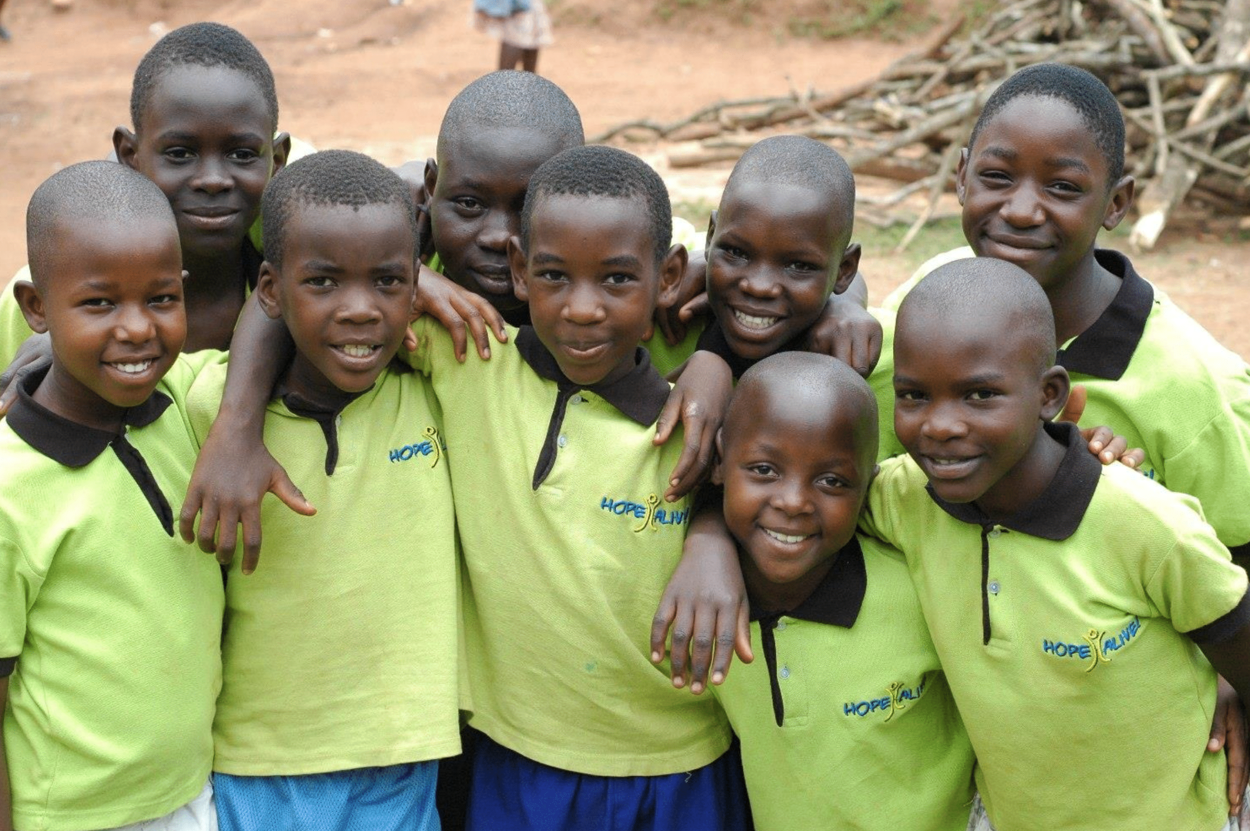 Group of smiling young students in yellow hope alive polo shirts