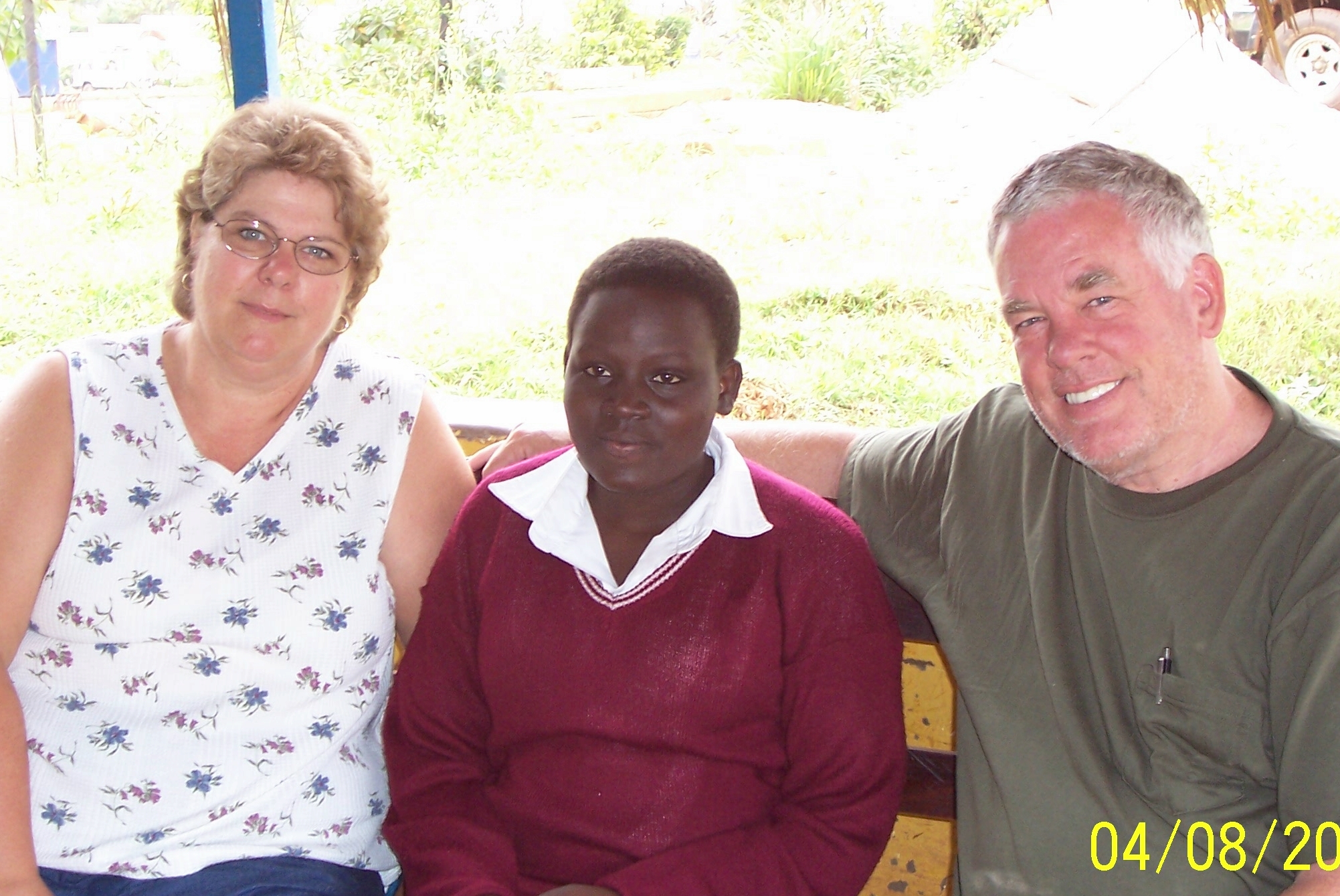 Ugandan girl flanked by American couple