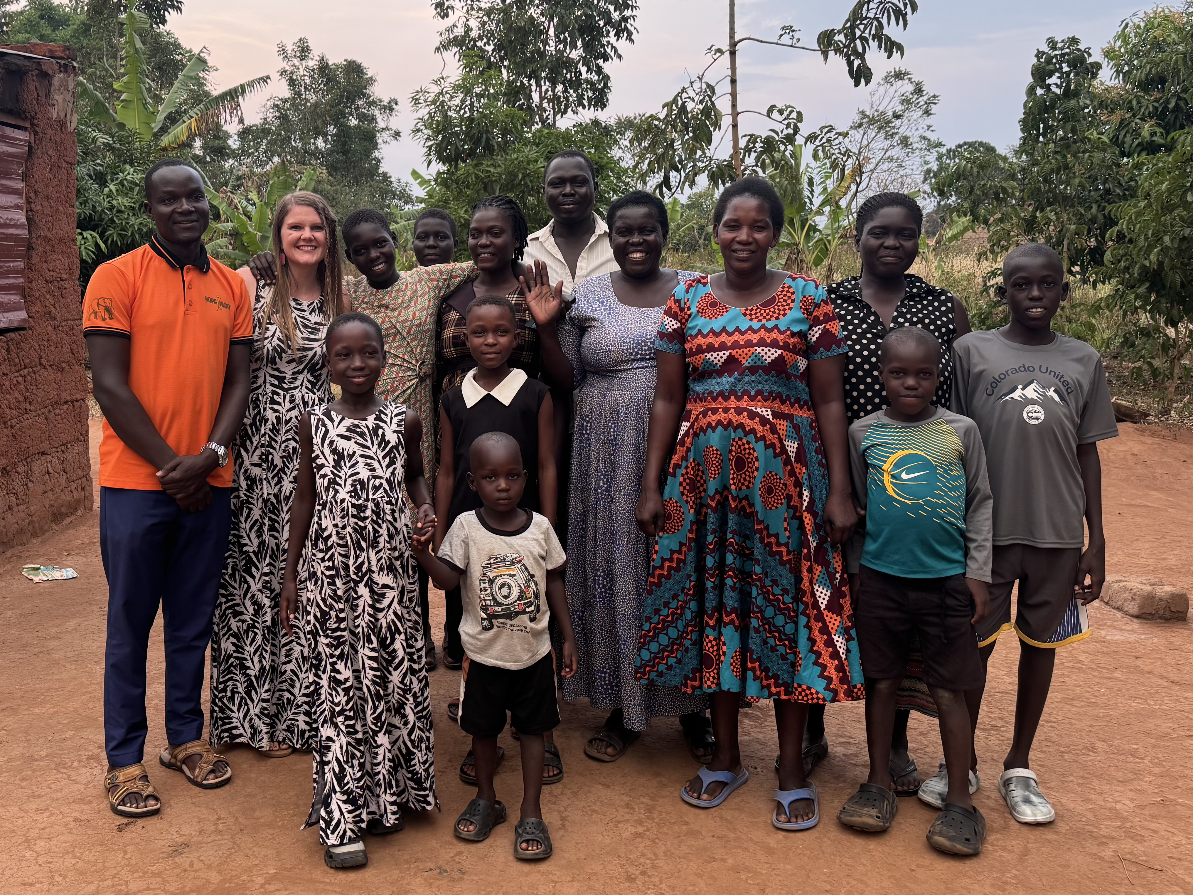 Teal poses for a photo with her sponsored student and family