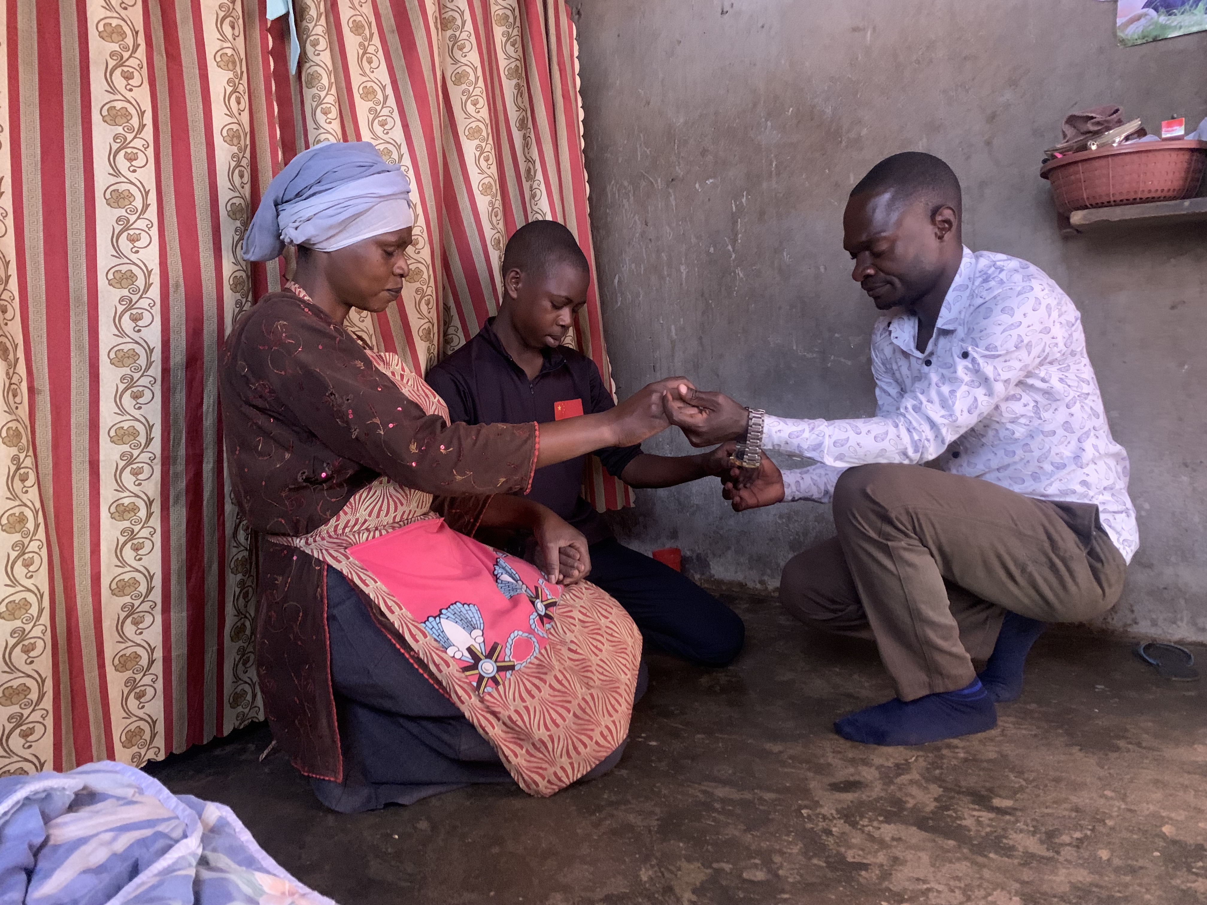 Three people in prayer, laying on of hands