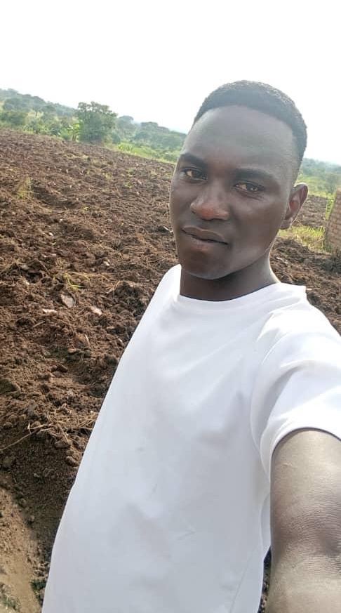 Man taking a selfie in front of a plowed field