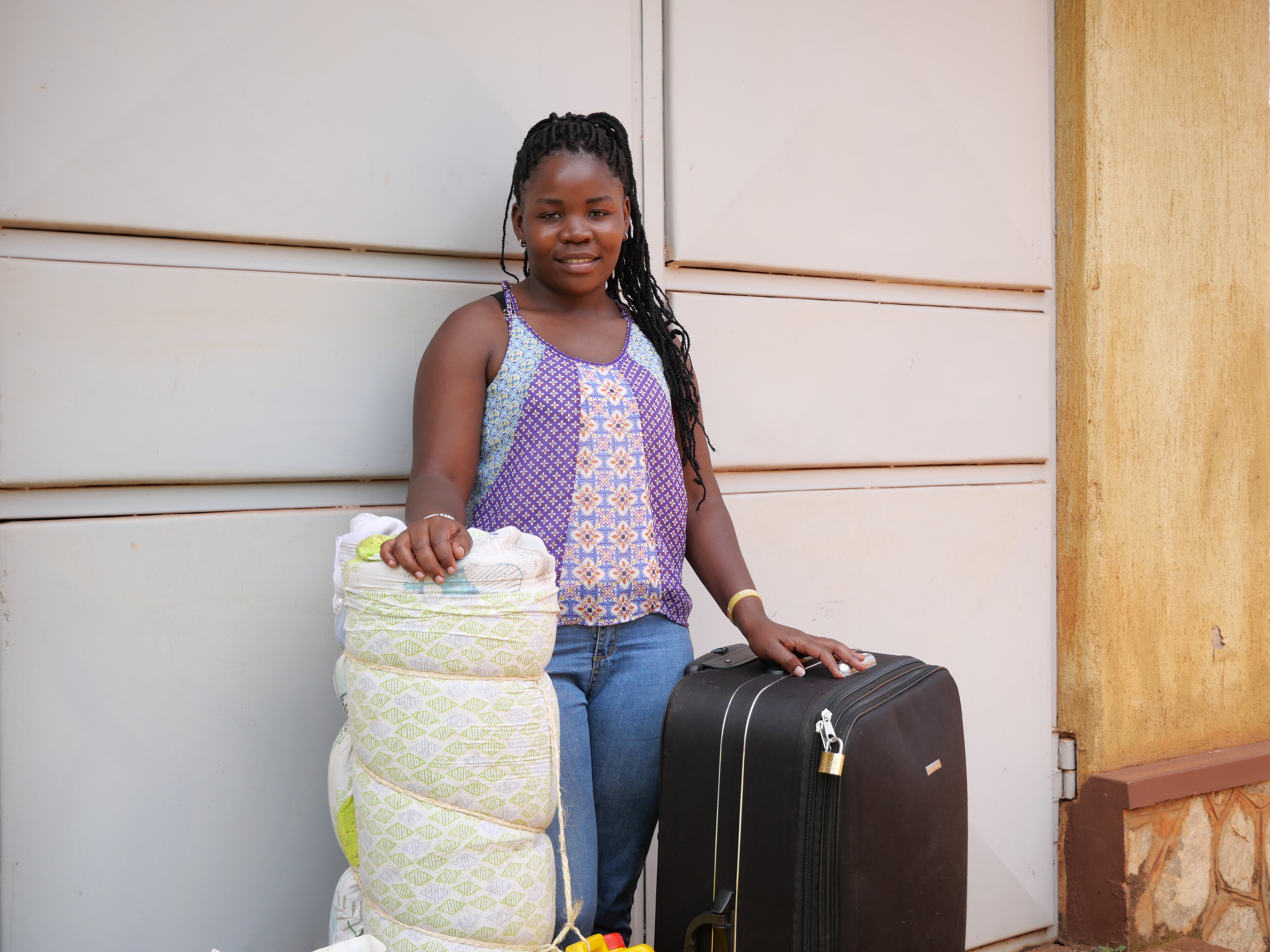 Female student with a suitcase and bedroll