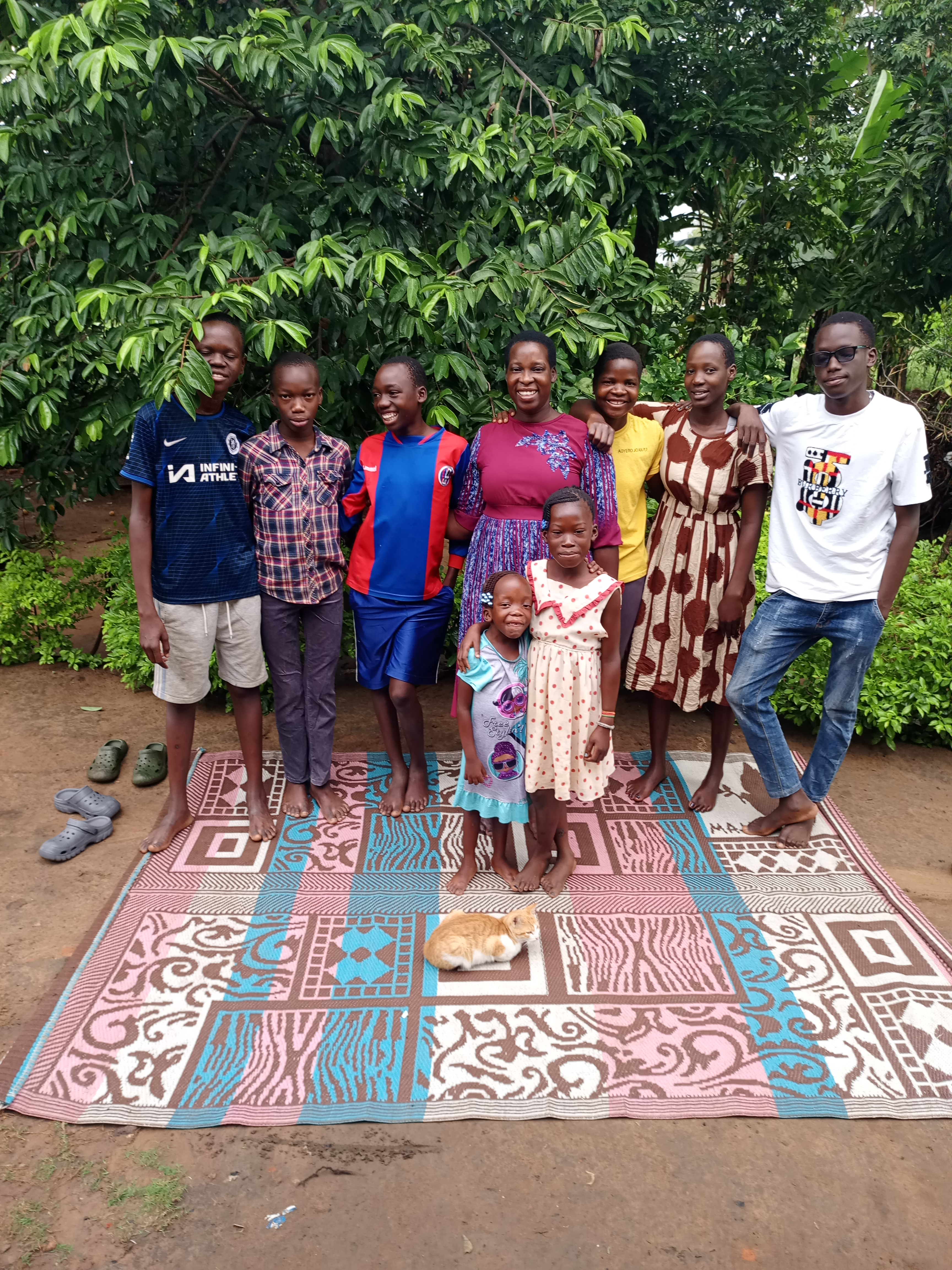 Aunt Sarah and extended family Family with grown children on rug, cat