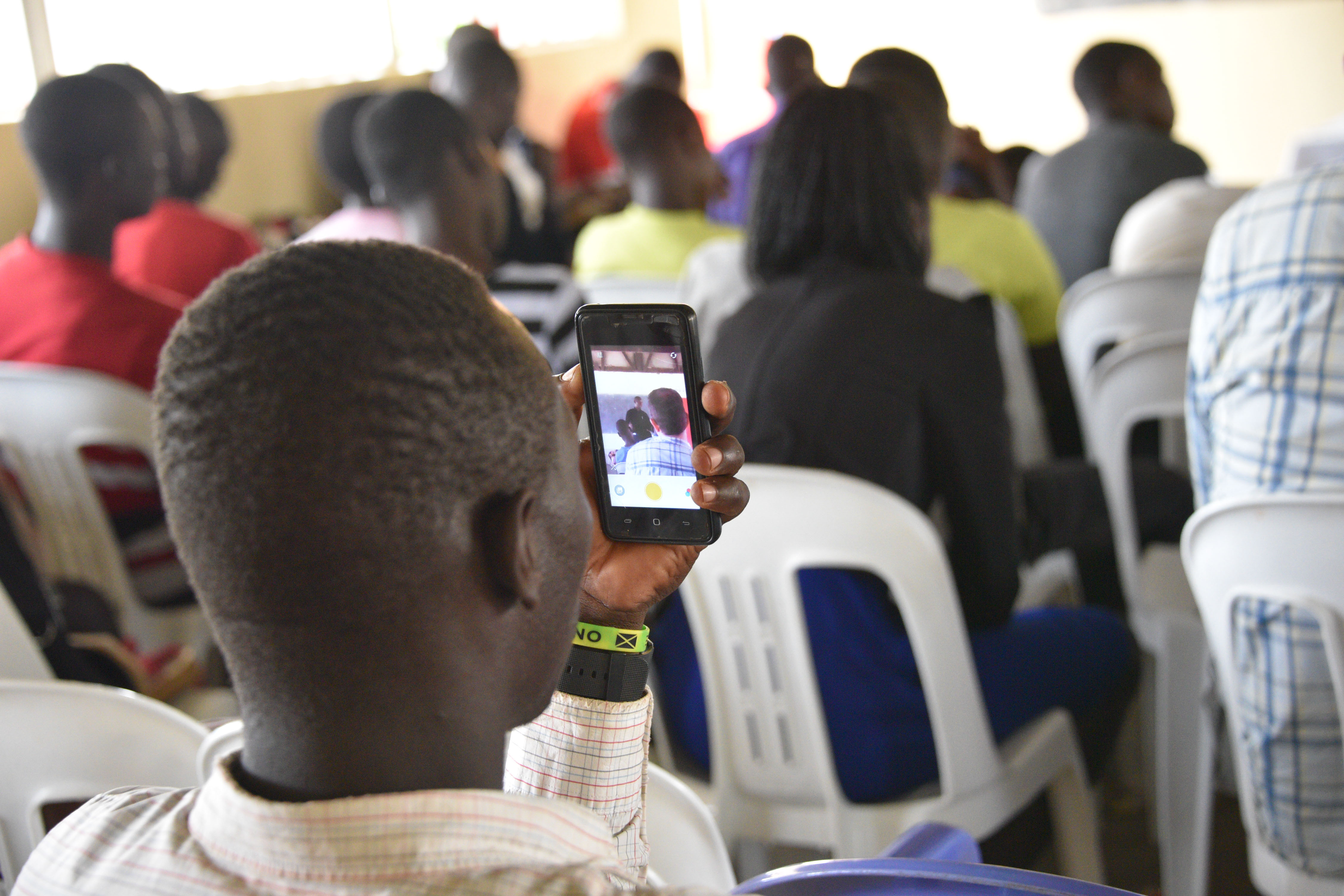 Student in class using a phone to take a photo