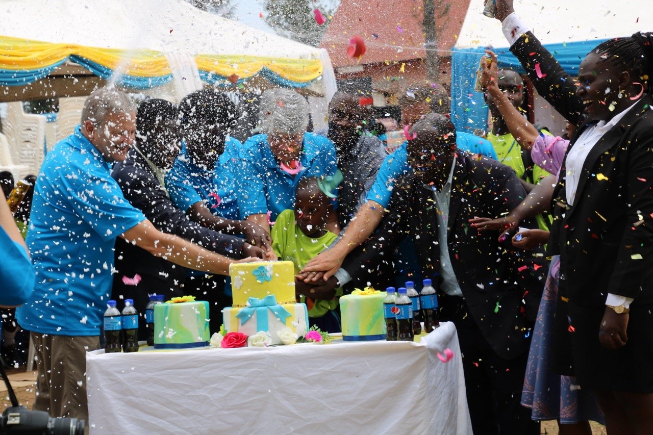 Board members and others around cake with confetti