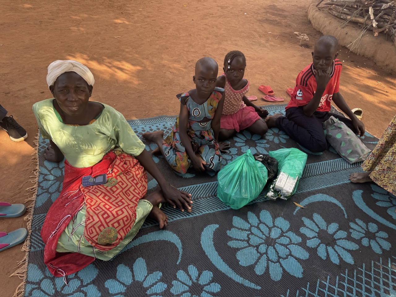 family outside hut on rug