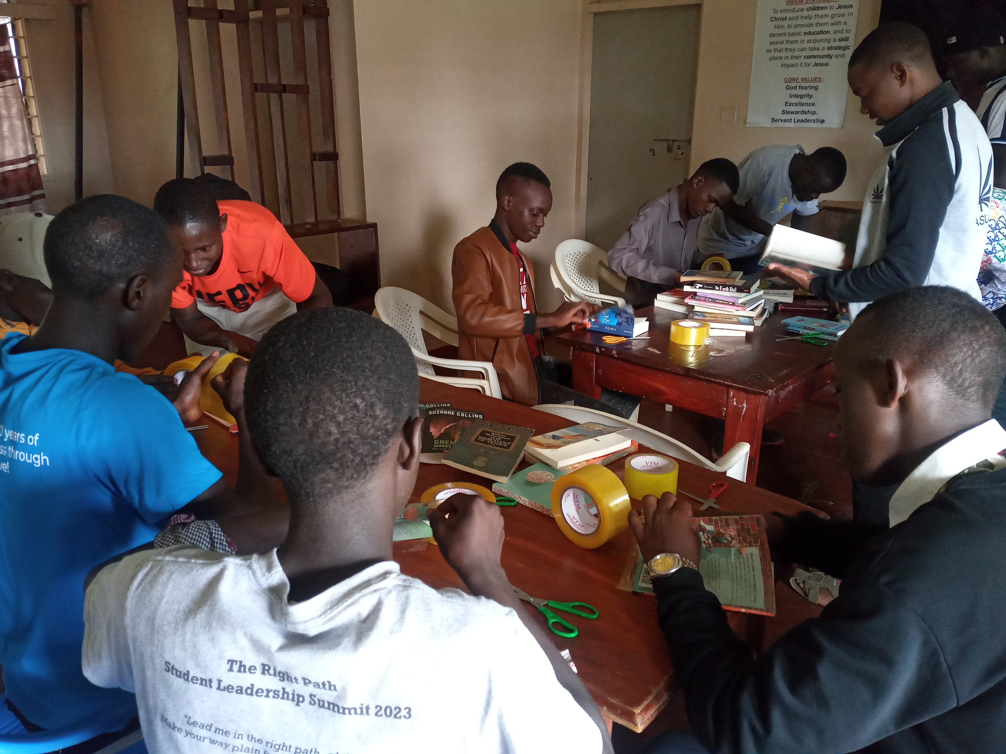 Students covering new book covers with clear packaging tape