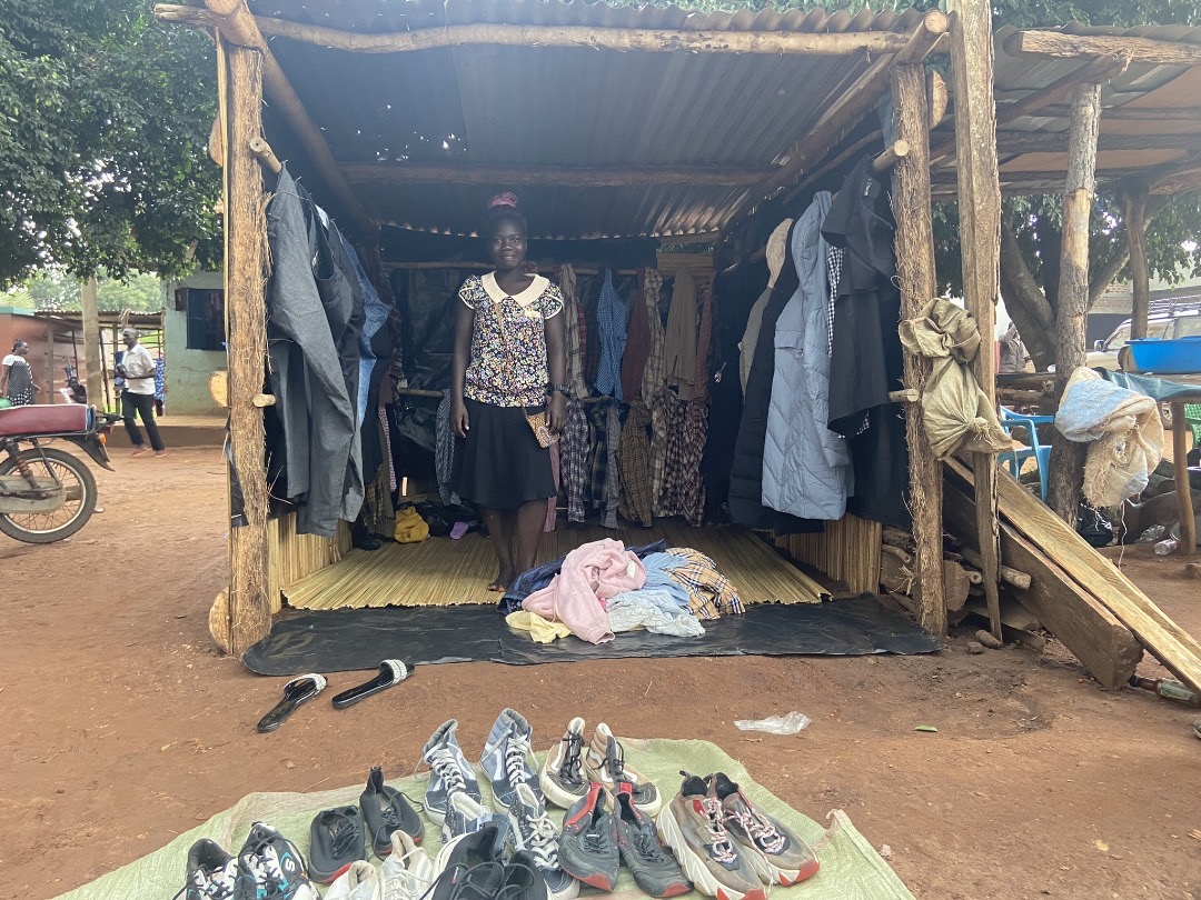 woman standing in an enclosure with clothing for sale